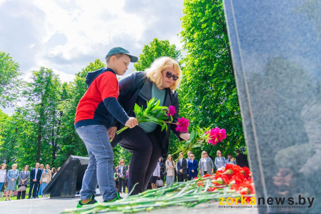 женщтна с ребенком возлагает цветы