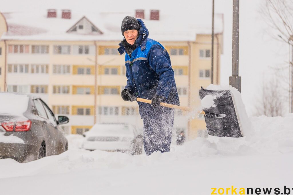 работник жкх чистит двор от снега