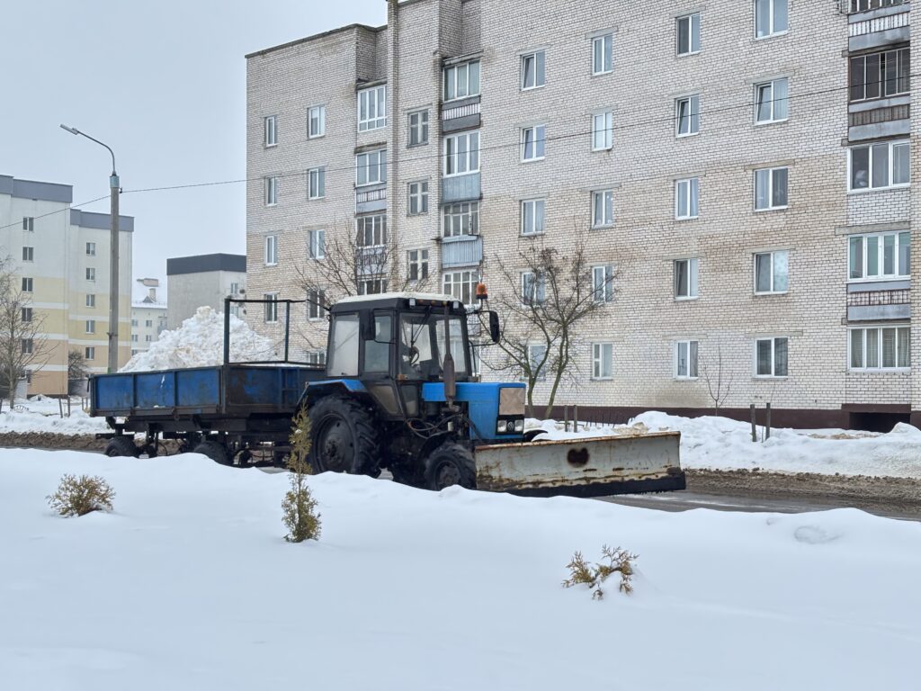 трактор убирает снег с дороги