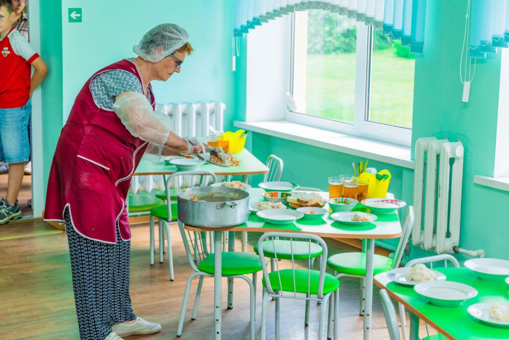 кухонный работник накрывает на стол