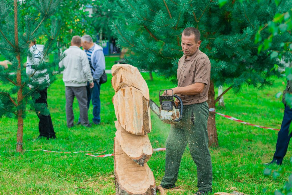 вырезает скульптуру из дерева